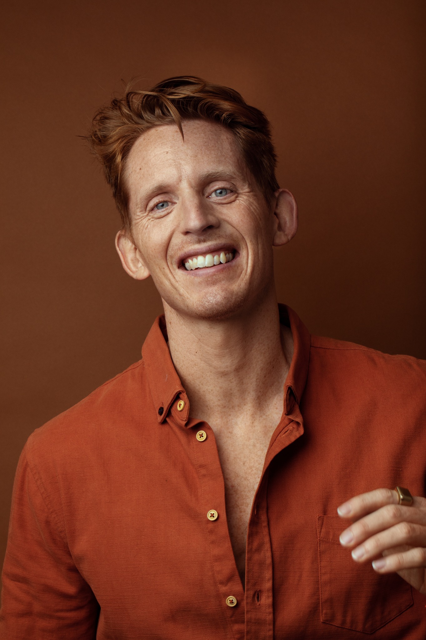 Andreas G. Hansen smiling in a rust-coloured shirt