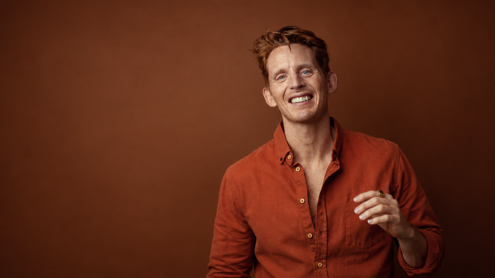 Andreas G. Hansen smiling in a rust-coloured shirt